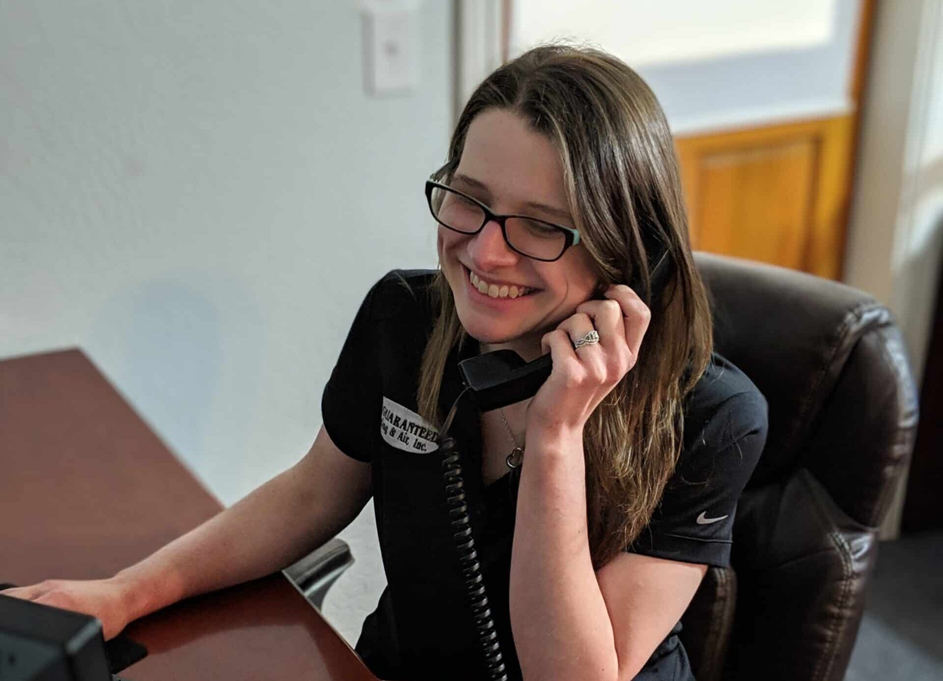 Happy A-1 Guaranteed team member answering telephone