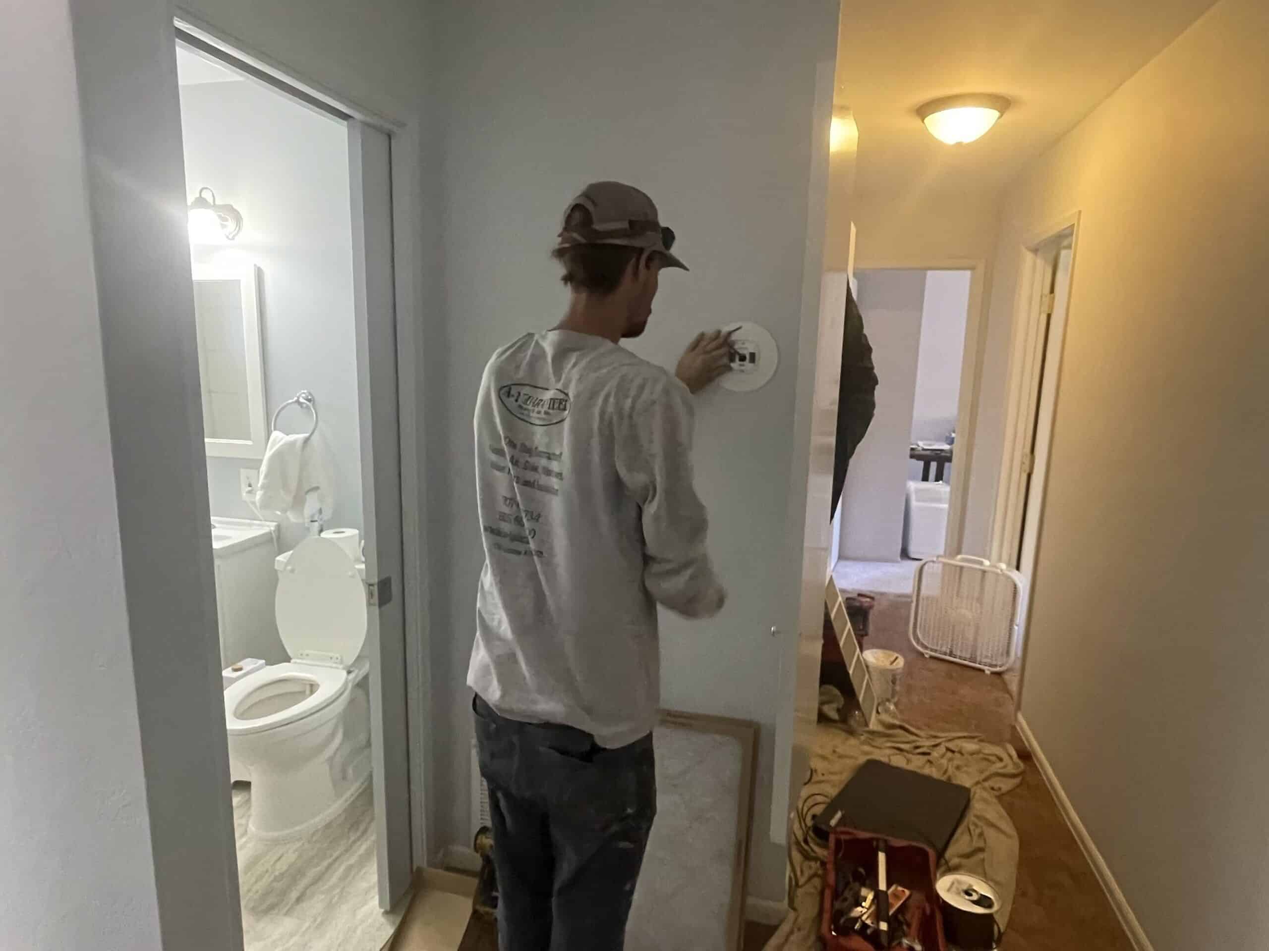 A-1 Guaranteed team member examining thermostat